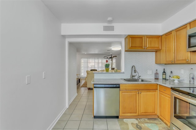 kitchen featuring light tile patterned floors, appliances with stainless steel finishes, sink, and backsplash