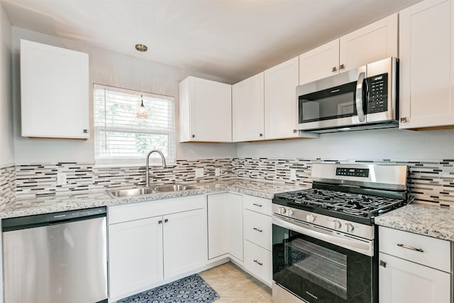 812 38th St, Galveston, TX 77550 - kitchen with appliances with stainless steel finishes, a sink, tasteful backsplash, and white cabinetry