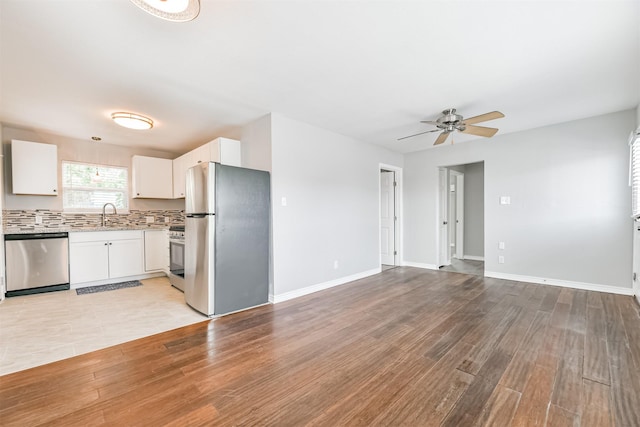 kitchen featuring appliances with stainless steel finishes, sink, light hardwood / wood-style flooring, and white cabinets