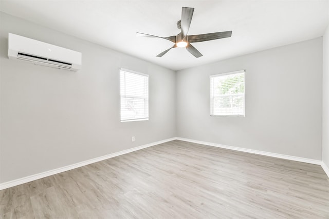 unfurnished room with ceiling fan, a wall unit AC, and light hardwood / wood-style flooring