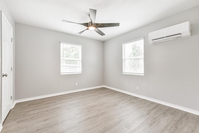 unfurnished room with a wall mounted air conditioner, plenty of natural light, ceiling fan, and light wood-type flooring