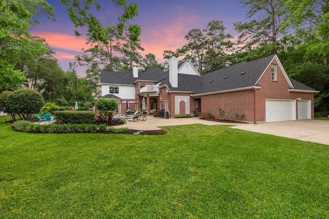 view of front of house with a garage, driveway, a front lawn, and brick siding