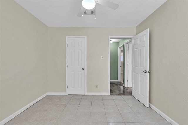 unfurnished bedroom featuring light tile patterned flooring and ceiling fan