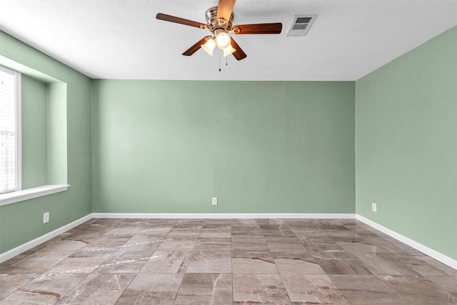 spare room featuring a textured ceiling and ceiling fan