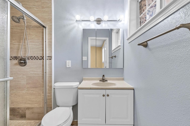 bathroom featuring vanity, an enclosed shower, and toilet