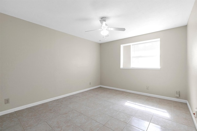 tiled spare room featuring ceiling fan