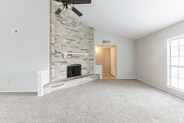 unfurnished living room featuring a brick fireplace, plenty of natural light, light carpet, and lofted ceiling