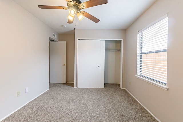 unfurnished bedroom featuring carpet, ceiling fan, and a closet