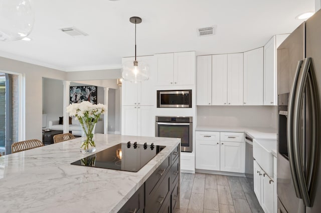 kitchen featuring crown molding, a breakfast bar area, white cabinets, and appliances with stainless steel finishes