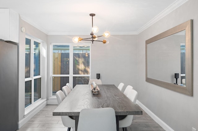 dining room featuring crown molding, light hardwood / wood-style floors, and a notable chandelier