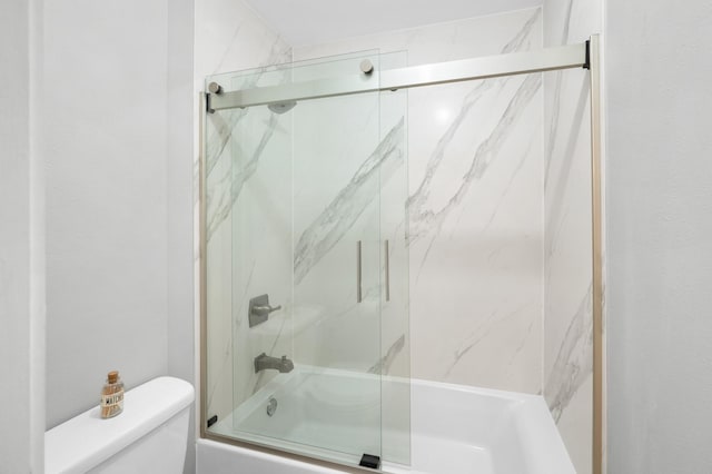 bathroom featuring shower / bath combination with glass door and toilet