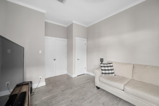 living room with crown molding and light hardwood / wood-style floors