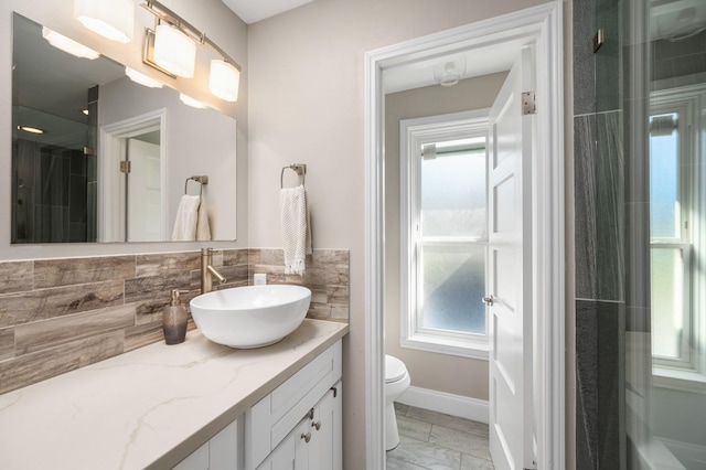 bathroom with vanity, tasteful backsplash, toilet, and walk in shower