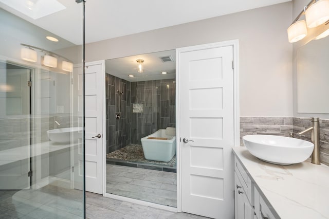 bathroom with vanity, a skylight, and a shower with door