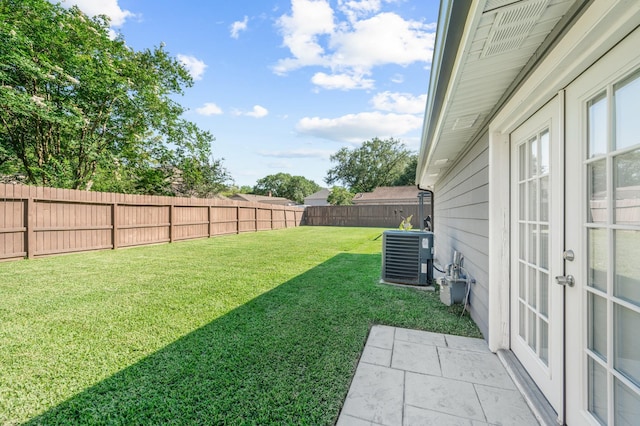 view of yard featuring central AC and french doors