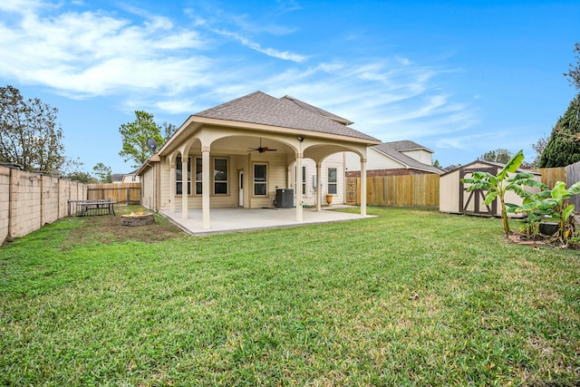 rear view of house with a lawn, ceiling fan, central AC, a patio area, and a storage shed