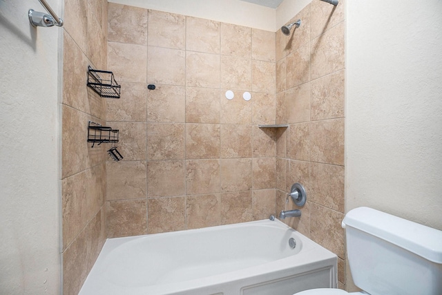 bathroom featuring tiled shower / bath and toilet