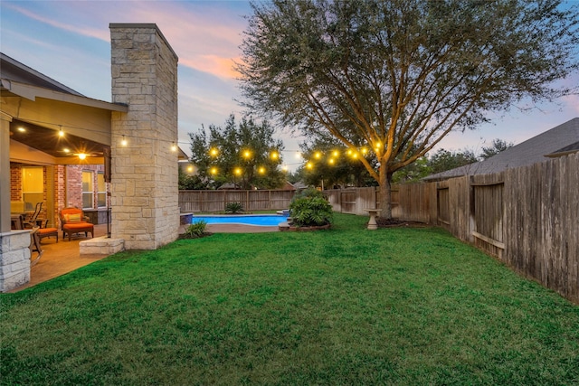 yard at dusk with a patio area, a fenced backyard, and a fenced in pool