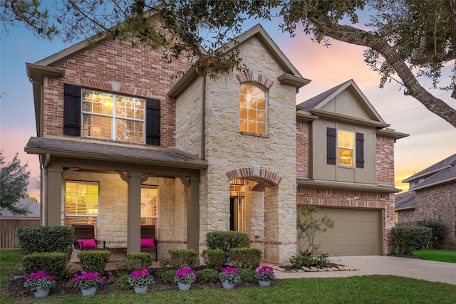 view of front of home featuring a garage, driveway, stone siding, fence, and brick siding