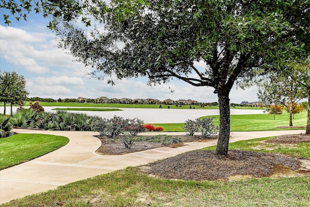 view of property's community with a yard and a water view