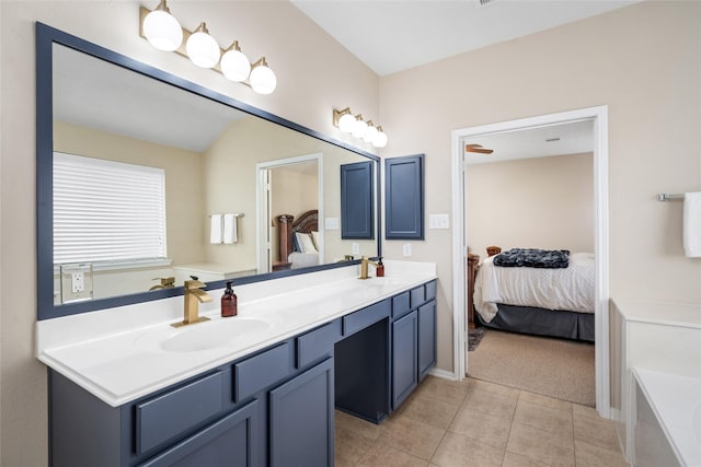 full bath with a tub to relax in, double vanity, ensuite bathroom, a sink, and tile patterned floors