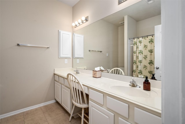 bathroom with double vanity, tile patterned flooring, baseboards, and a sink