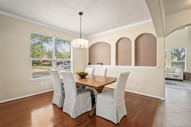 dining area featuring baseboards, wood finished floors, a wealth of natural light, and an inviting chandelier