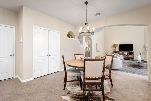 dining area with arched walkways, visible vents, an inviting chandelier, light tile patterned flooring, and baseboards