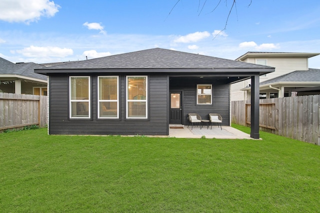 rear view of house featuring a yard and a patio