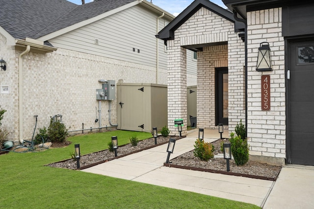 view of exterior entry with a yard