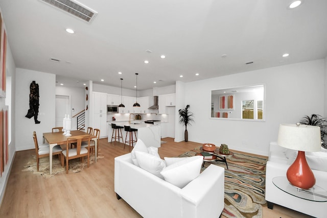 living room featuring sink and light hardwood / wood-style flooring