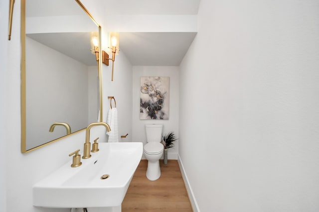 bathroom with wood-type flooring, sink, and toilet