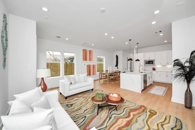 living room with sink and light hardwood / wood-style floors