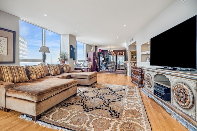 living room with a notable chandelier and light hardwood / wood-style flooring