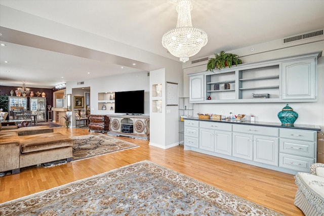 living room with an inviting chandelier and light hardwood / wood-style flooring