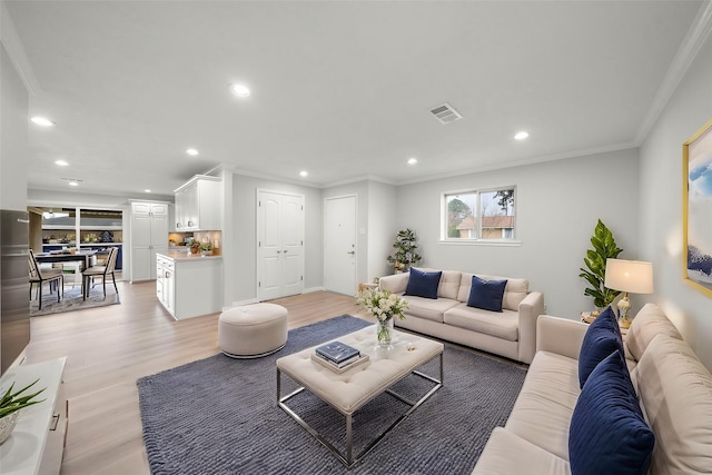 living room with crown molding and light wood-type flooring