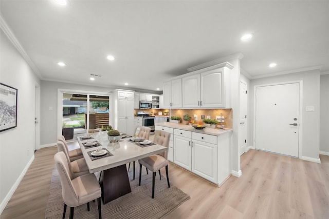 dining area featuring crown molding and light hardwood / wood-style flooring