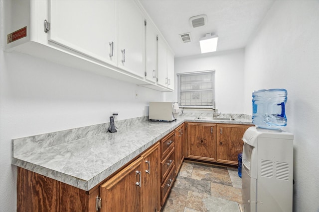 laundry room with cabinets and sink