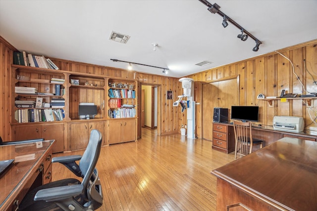 office area featuring wooden walls, light hardwood / wood-style floors, and rail lighting