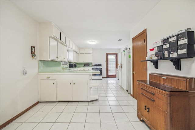 kitchen with light tile patterned floors, white cabinets, white appliances, and kitchen peninsula