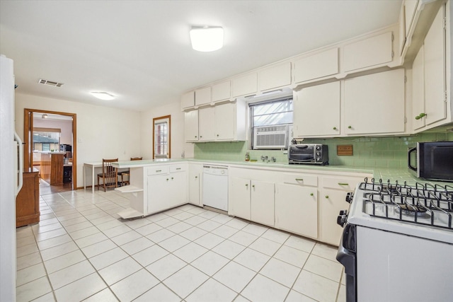 kitchen featuring light tile patterned flooring, backsplash, white cabinets, and white appliances