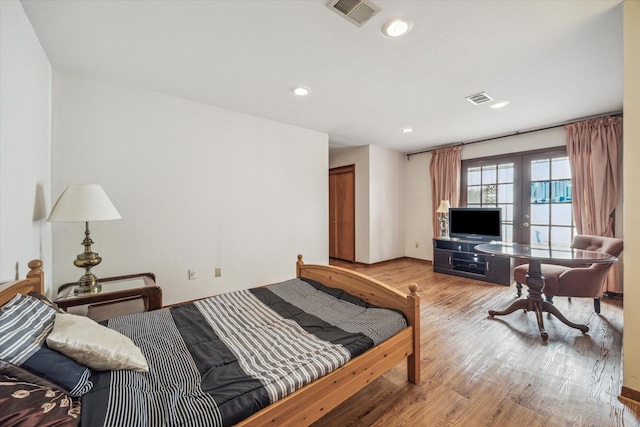 bedroom with french doors and light hardwood / wood-style floors