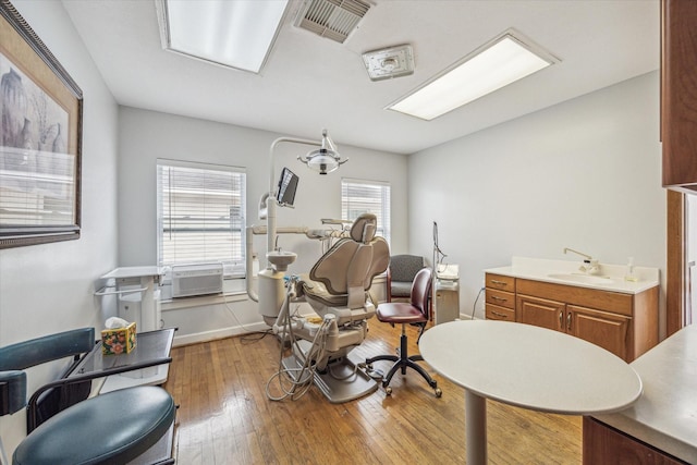 interior space featuring a wall mounted air conditioner, sink, and hardwood / wood-style floors