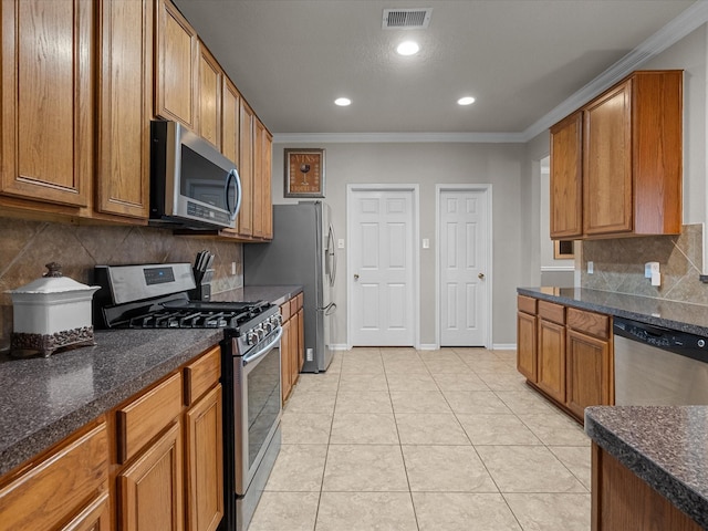 kitchen featuring crown molding, appliances with stainless steel finishes, light tile patterned flooring, and backsplash