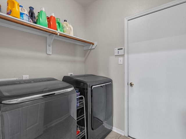 laundry room featuring light tile patterned floors and washer and clothes dryer