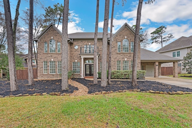 view of front property featuring a carport, a balcony, and a front lawn