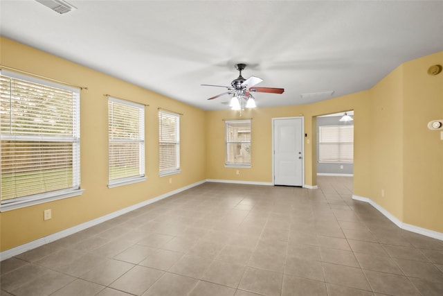 tiled spare room featuring plenty of natural light and ceiling fan