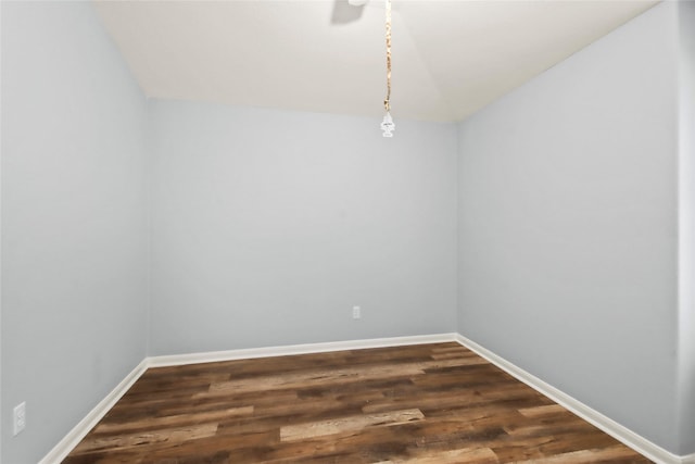 empty room with vaulted ceiling and dark hardwood / wood-style flooring