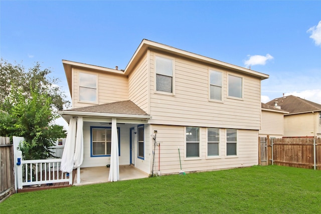 rear view of house with a patio and a yard