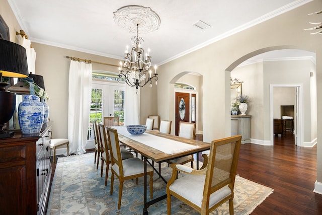 dining area featuring an inviting chandelier, ornamental molding, dark hardwood / wood-style floors, and french doors